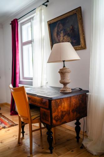 a desk with a lamp and a chair in a room at Florian's Haus in Cisnădioara