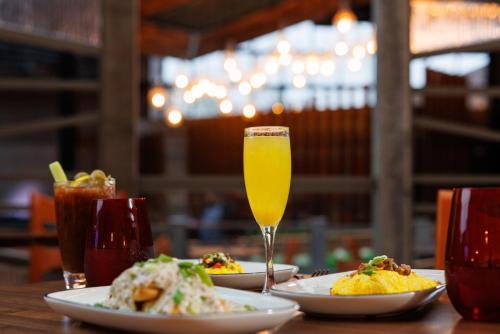 a table with plates of food and a glass of orange juice at Bally's Baton Rouge Hotel in Baton Rouge