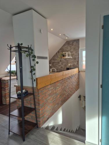 a staircase in a kitchen with a brick wall at Tündérkert Tündérfészek Vendégház in Sződliget