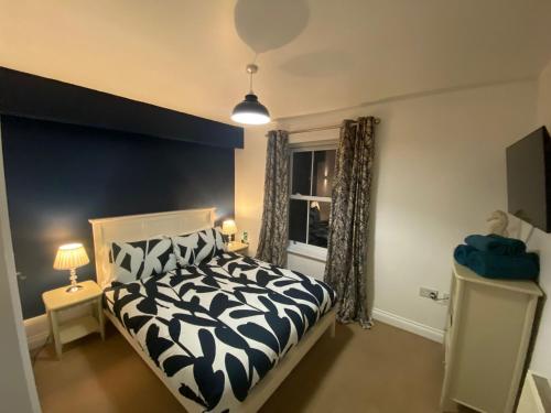 a bedroom with a black and white bed and a window at Seaglass, The Bay - Filey Ground Floor Step Free Easy Access and Parking in Filey