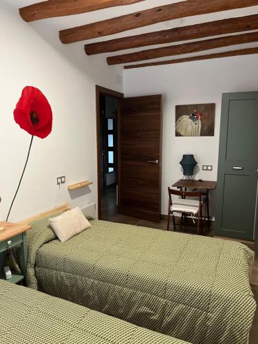 a bedroom with two beds and a red flower on the wall at La Casa Vella in Navarcles