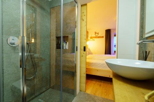 a bathroom with a glass shower and a sink at B&B Luggla - sauna in camera in Predoi