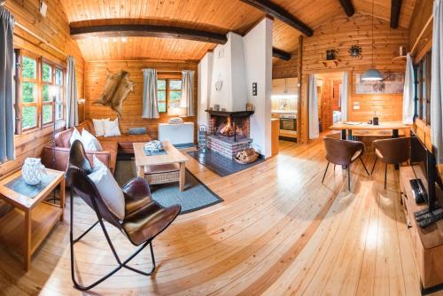 a living room with a fireplace in a log cabin at Bergcottage in Neerdar