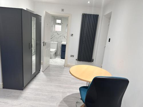 a room with a table and a chair and a bathroom at Large Double Bed En-suite Room 20 mins from Heathrow in Burnham