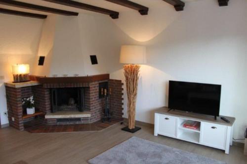 a living room with a fireplace and a flat screen tv at Chalet La Belle Willingen in Willingen