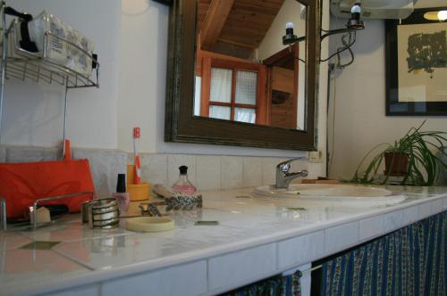 een badkamerbar met 2 wastafels en een spiegel bij El Arcon in Simancas