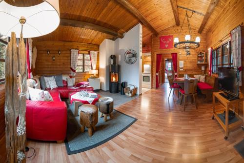 a living room with red furniture and a wooden ceiling at Hirsch Chalet in Bömighausen