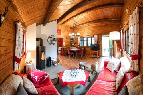 a living room with a red couch and a table at Hirsch Chalet in Bömighausen