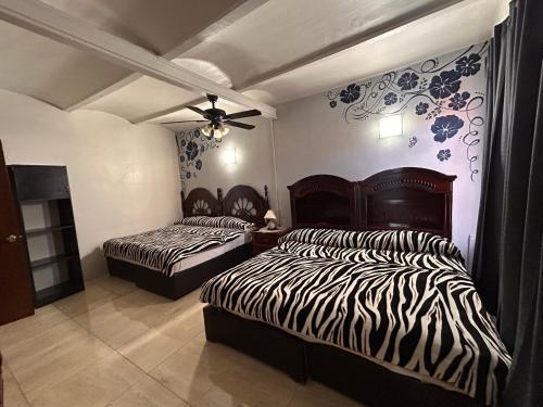 a bedroom with two beds and a ceiling fan at El Hogar de Carmelita in Guanajuato