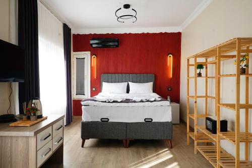 a bedroom with a bed and a red wall at The Apartment Galata in Istanbul