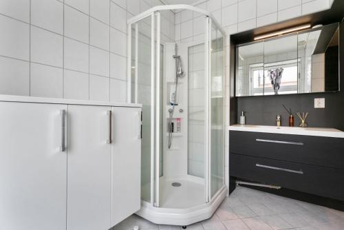 a white bathroom with a shower and a sink at Centrum apartment 2 in Ålesund