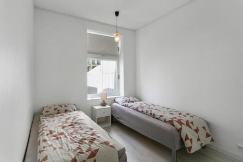 a bedroom with two beds and a window at Centrum apartment 2 in Ålesund