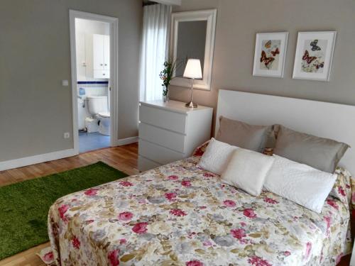 a bedroom with a bed with a floral bedspread at Apartamento Getxo Tranquility by I Love Norte in Getxo