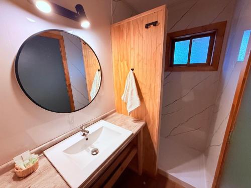 a bathroom with a sink and a mirror at Cabañas Agua y Campo in Osorno