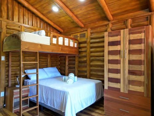 a bedroom with bunk beds in a wooden cabin at Cabañas Samara Buenavista in Sámara