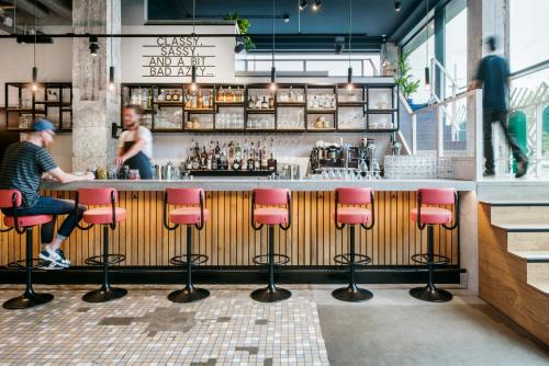 a bar with pink stools at a counter at The Social Hub Rotterdam Extended Stay in Rotterdam