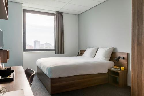 a hotel room with a bed and a window at The Social Hub Rotterdam Extended Stay in Rotterdam