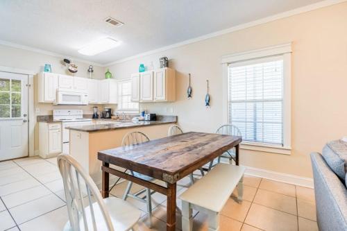 a kitchen and dining room with a wooden table and chairs at Orange Beach Villas - Allure by Youngs Suncoast in Orange Beach