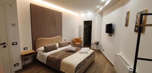 a hotel room with a bed and a television at CarMa Luxury Rooms in Linguaglossa