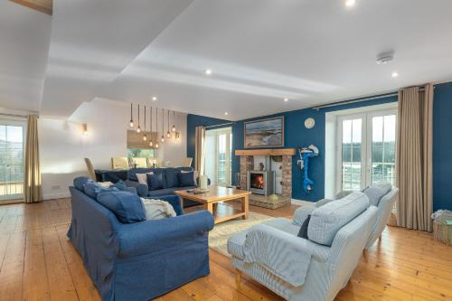 a living room with two blue couches and a fireplace at The Old Mill, Deluxe holiday home with a view in Menai Bridge