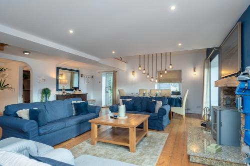 a living room with blue couches and a table at The Old Mill, Deluxe holiday home with a view in Menai Bridge