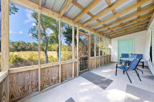 a wooden screened porch with a table and chairs at Orange Beach Villas - Beach Retreat by Youngs Suncoast in Orange Beach
