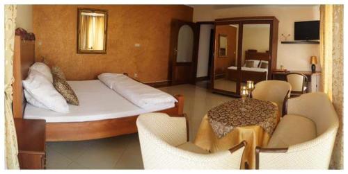 a bedroom with a bed and a table and chairs at Penzion Vegas in Partizánske