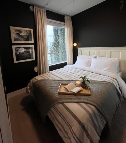 a bedroom with a bed with a tray with two books at Modern & Stylish Condo in Langley City in Langley