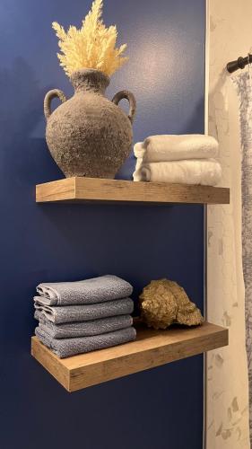a shelf with towels and a vase on it at Modern & Stylish Condo in Langley City in Langley