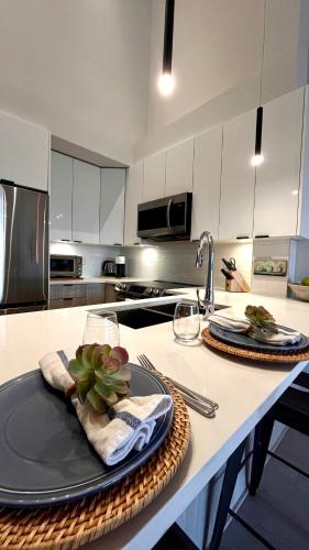 a kitchen with a table with plates and napkins at Modern & Stylish Condo in Langley City in Langley