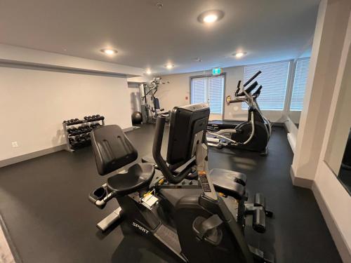 a gym with two treadmills and two exercise bikes at Modern & Stylish Condo in Langley City in Langley