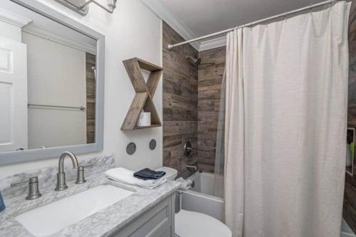 a bathroom with a sink and a toilet and a mirror at The Hourglass Inn- Unit B in Savannah