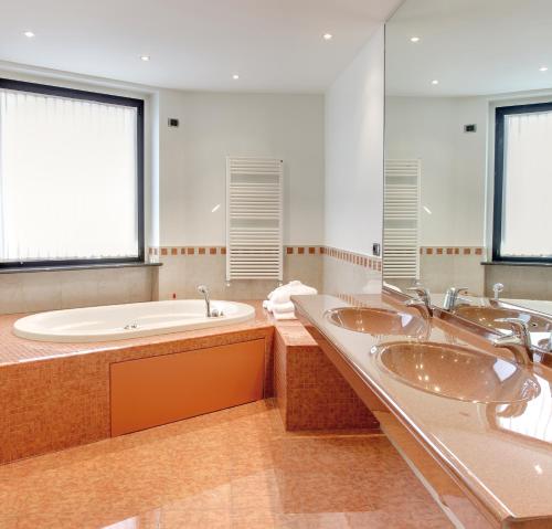 a bathroom with three sinks and a bath tub at Hotel Nord in Guardamiglio