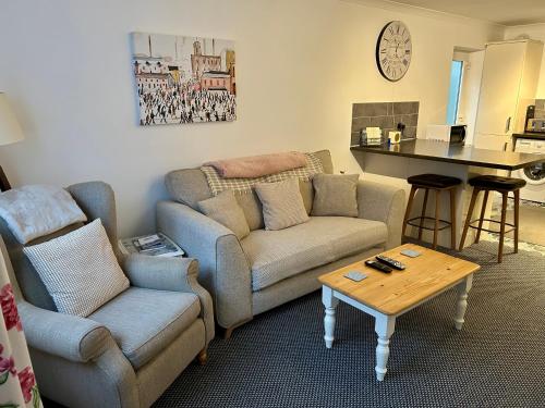 a living room with a couch and a table at Modern 2 Bedroom Ground Floor Apartment with Parking Ripon City Centre in Ripon