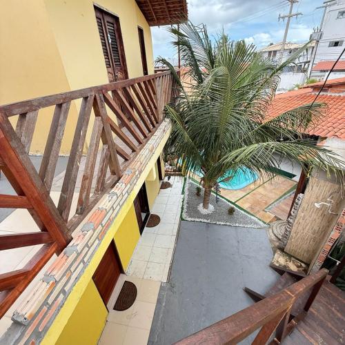 a balcony of a house with a palm tree at Sertão beach in Tutóia