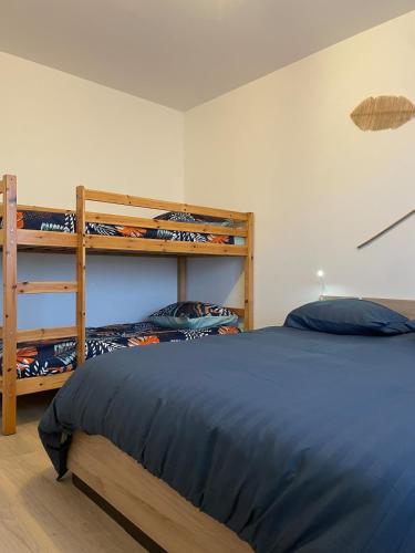a bedroom with a bed and two bunk beds at Parenthèse 8 pers-6 mns Futuroscope-Famille in Chasseneuil-du-Poitou
