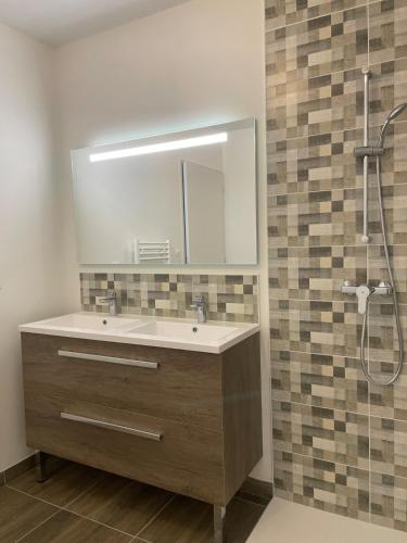 a bathroom with a sink and a shower with a mirror at Parenthèse 8 pers-6 mns Futuroscope-Famille in Chasseneuil-du-Poitou