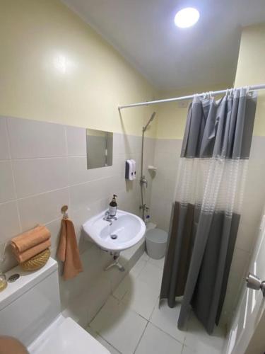 a bathroom with a sink and a toilet and a shower at Sanremo Oasis, City di Mare, SRP in Cebu City
