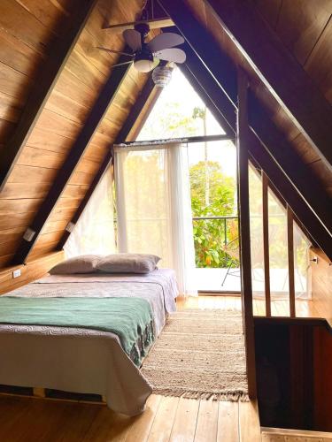a bedroom with a bed and a large window at Cabañas Toku Laka in Fortuna