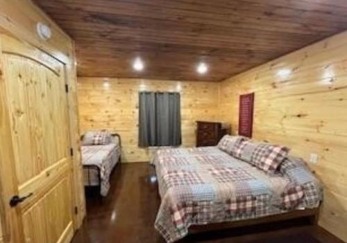 a bedroom with two beds in a wooden cabin at Blue Cozy Cottage in Oneida