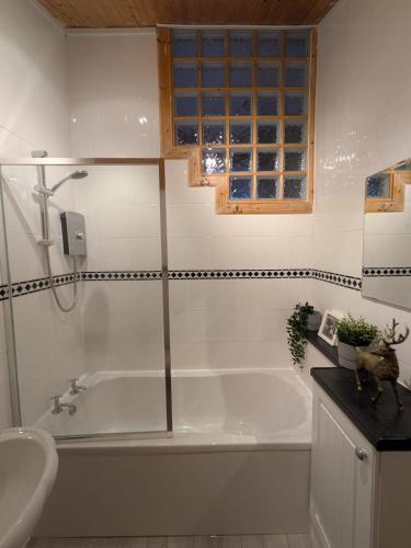 a bathroom with a tub and a sink at Beautiful Upper Apartment/Stunning Sea Views, Isle of Bute in Port Bannatyne