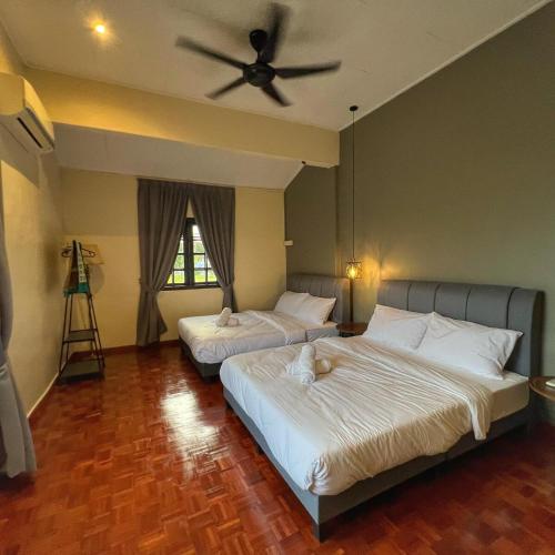 two beds in a bedroom with a ceiling fan at A6886 Swimming Pool Villa in Kuantan