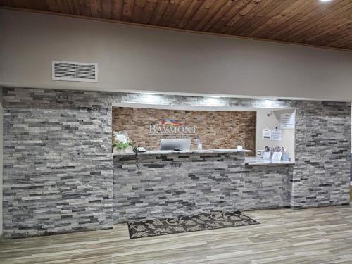 a restaurant with a brick wall with a laptop on it at Baymont by Wyndham Baldwin in Baldwin