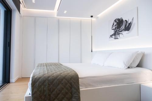a small bedroom with a bed with white walls at The L Smart Suite - Premium & Minimal in Ierapetra