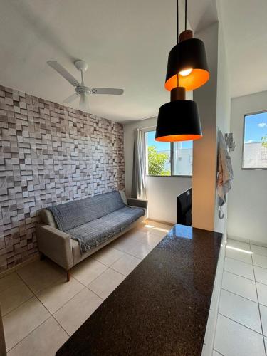 a living room with a couch and a brick wall at Apartamento prático e aconchegante - 5 min do Centro in Catanduva