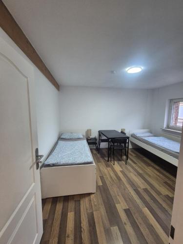a room with two beds and a table in it at Süder11 - ApartB in Eddelak