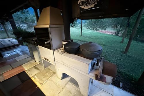 an outdoor kitchen with pots and pans on a table at Refugio da Serra - Cachoeira dos Bufalos in Pindamonhangaba