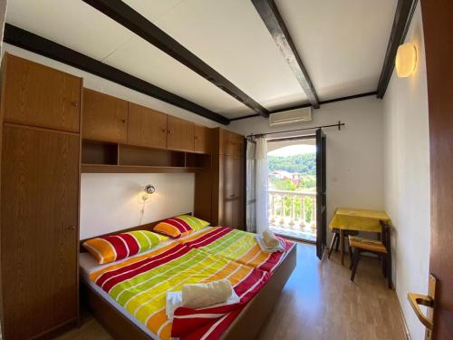 a bedroom with a large bed with colorful pillows at Apartment Solara in Kampor