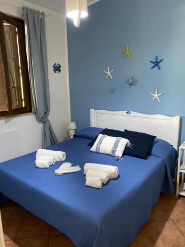 a blue bed with towels on top of it at Villa Verabetta in San Vito lo Capo