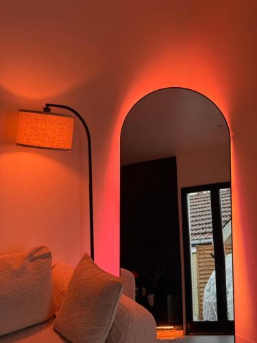 a room with a mirror and a lamp and a couch at Appartement jacuzzi d'exception - proche Paris in Drancy